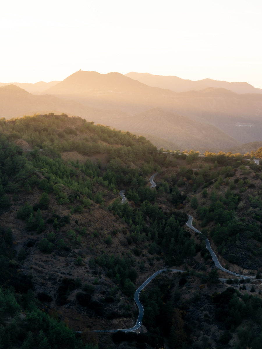 A road winds through the mountains of Cyprus at sunset