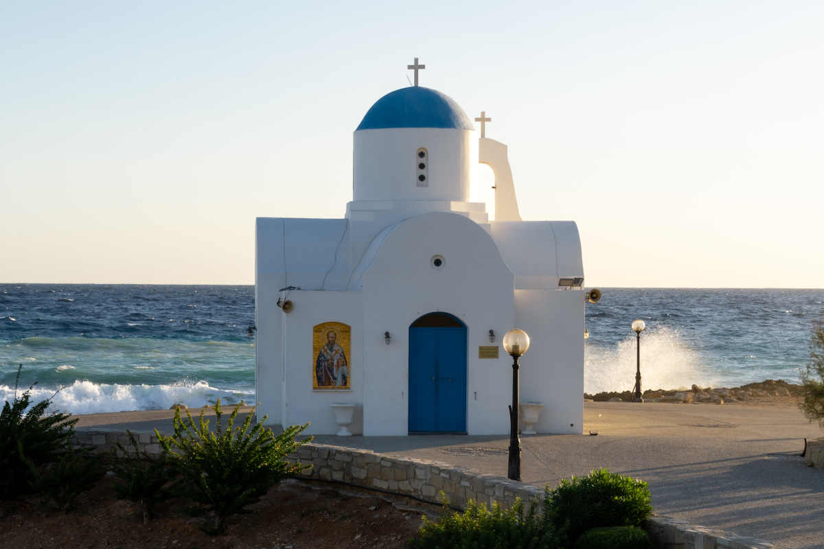 White church with blue doors and windows on the coast of Cyprus